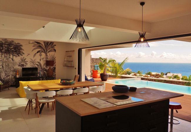 La cuisine ouverte donnant sur la piscine et l’océan – Villa Naézora, villa 10 personnes avec piscine à Saint-Gilles-les-Bains, La Réunion