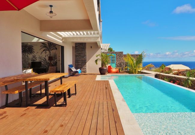 Grande table en bois et bancs sur la terrasse au bord de la piscine – Villa Naézora, villa 10 personnes avec piscine à Saint-Gilles-les-Bains, La Réunion