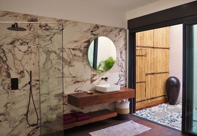 La salle de bain en marbre blanc ouvrant sur un patio – Villa Naézora, villa 10 personnes avec piscine à Saint-Gilles-les-Bains, La Réunion