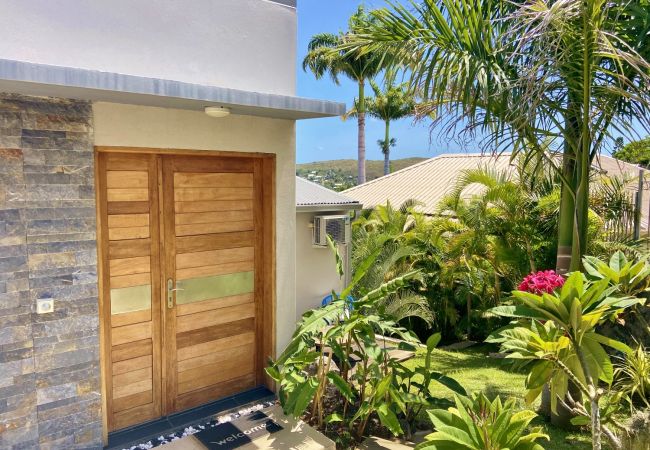 La grande porte en bois de la villa entourée d’un jardin tropical – Villa Naézora, villa 10 personnes avec piscine à Saint-Gilles-les-Bains, La Réunion