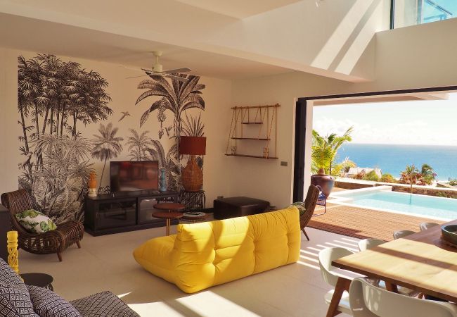 Le salon avec sa fresque végétale et sa vue sur la mer – Villa Naézora, villa 10 personnes avec piscine à Saint-Gilles-les-Bains, La Réunion