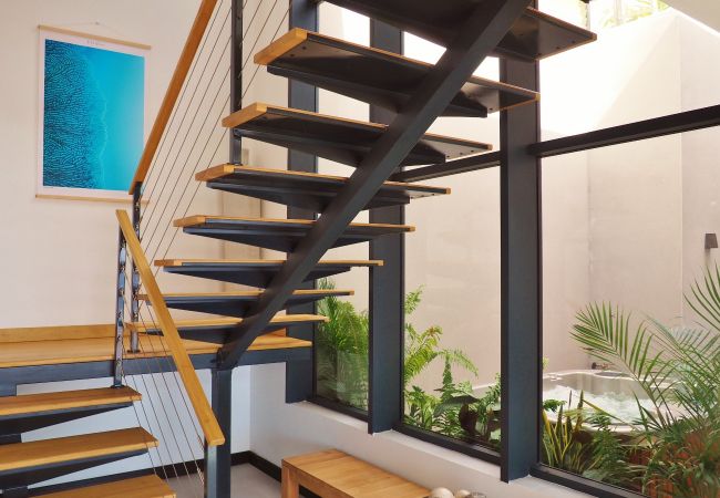 Escalier suspendu en bois et métal noir avec vue sur le jacuzzi de la véranda – Villa Naézora, villa 10 personnes avec piscine à Saint-Gilles-les-Bains, La Réunion