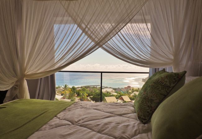 Lit à baldaquin avec voilages blancs et vue sur l’océan – Villa Naézora, villa 10 personnes avec piscine à Saint-Gilles-les-Bains, La Réunion