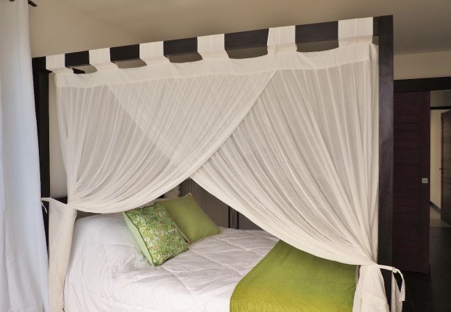 Lit à baldaquin avec voilages blancs et coussins verts – Villa Naézora, villa 10 personnes avec piscine à Saint-Gilles-les-Bains, La Réunion